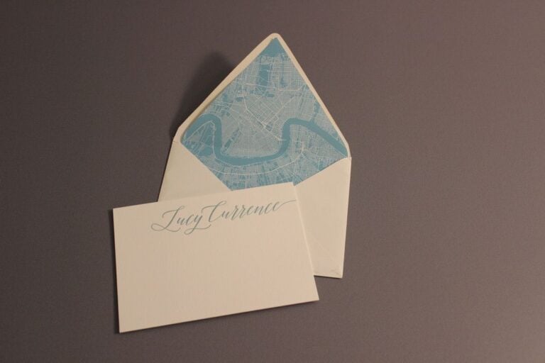 Cream envelope with a printed liner beside a card printed with an individual name