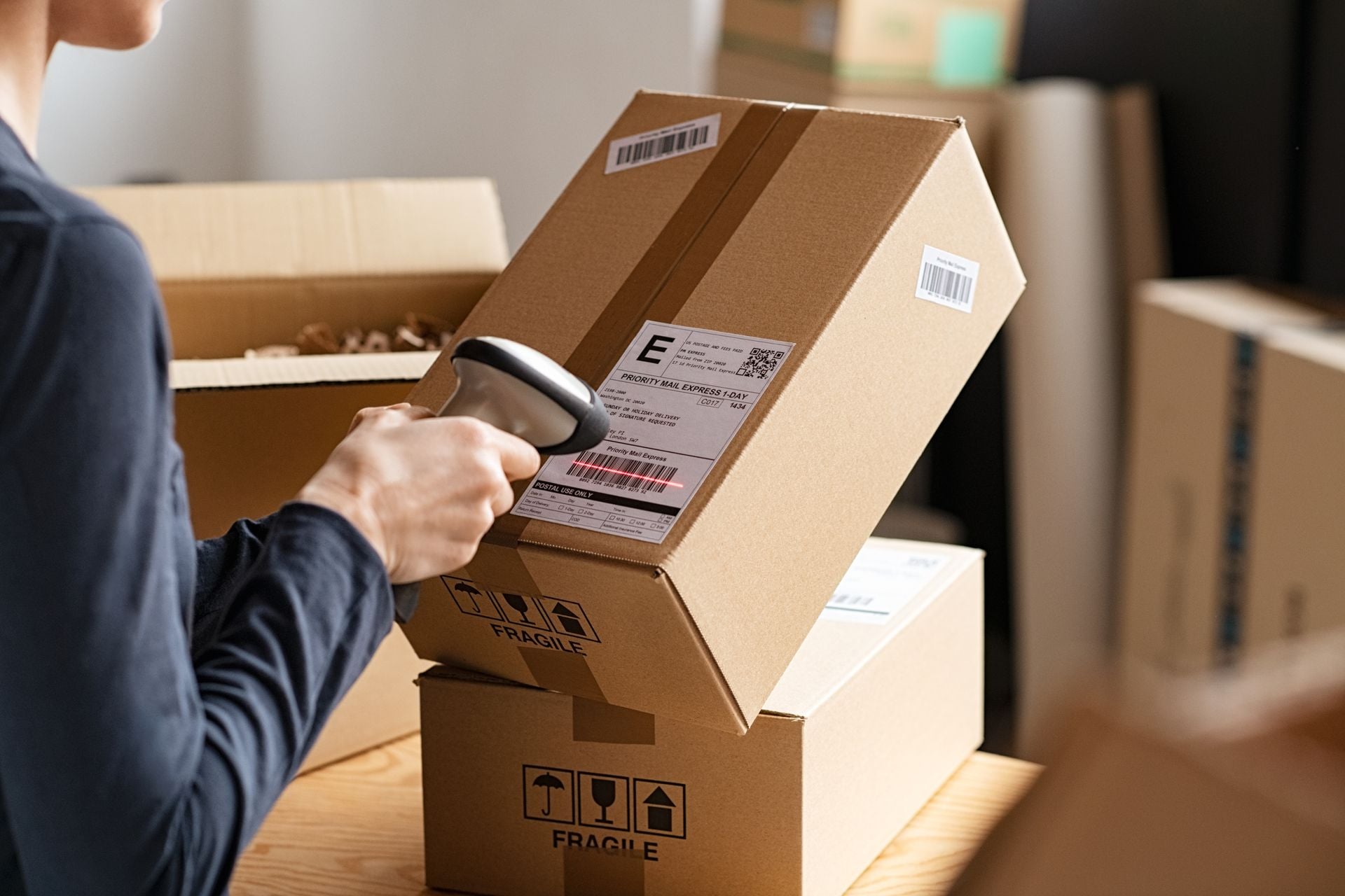 Hands scanning a barcode label on a corrugated shipping box
